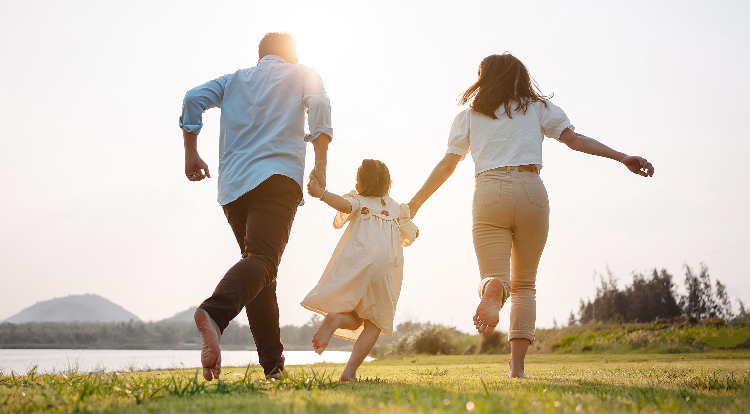 Family running together in nature at sunset.